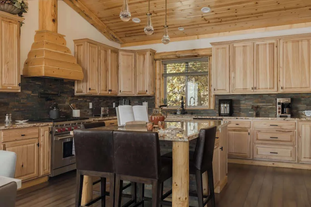 Chef kitchen with wood cabinetry, island and commercial range