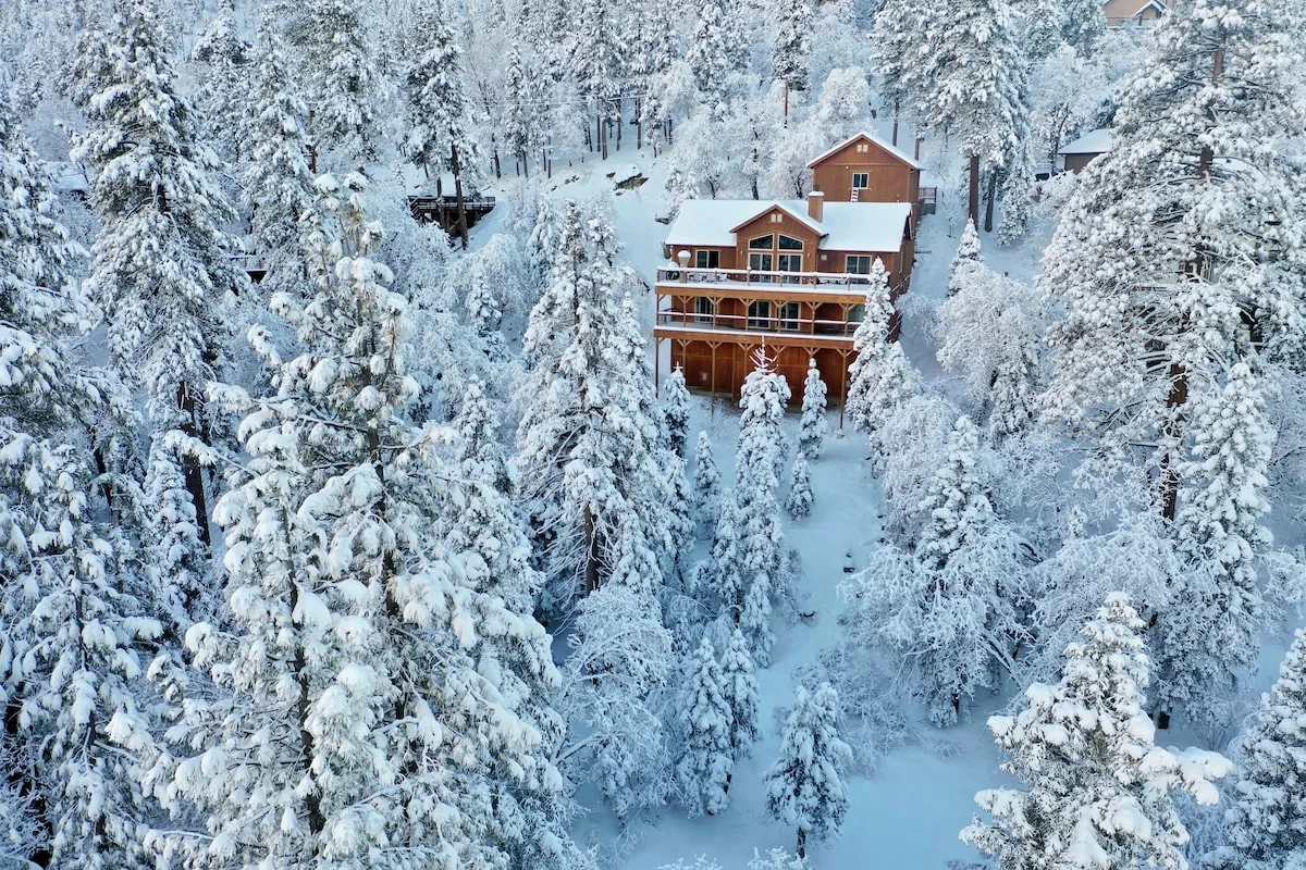 Aerial winter view of Eagle's Peak Lodge surrounded by snow-covered pine trees