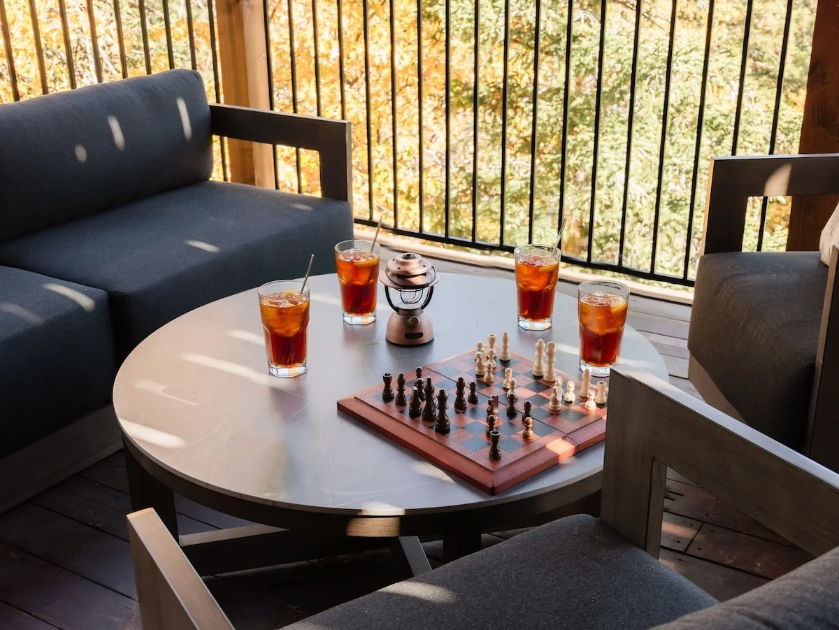 Deck seating with chess board and drinks overlooking the trees