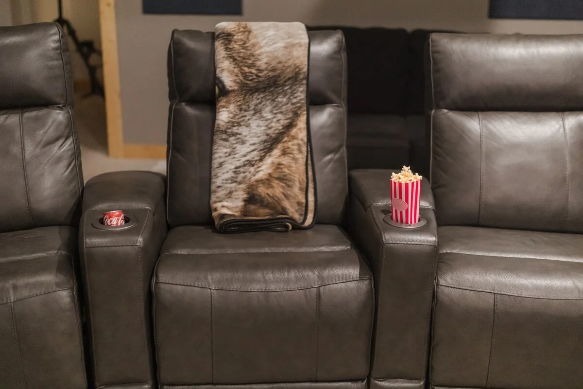 Close view of leather theater recliners with popcorn