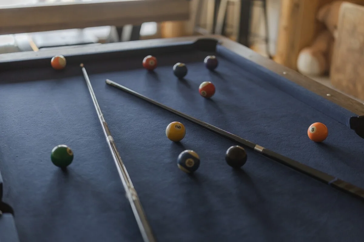 Close view of the billiards table and cues