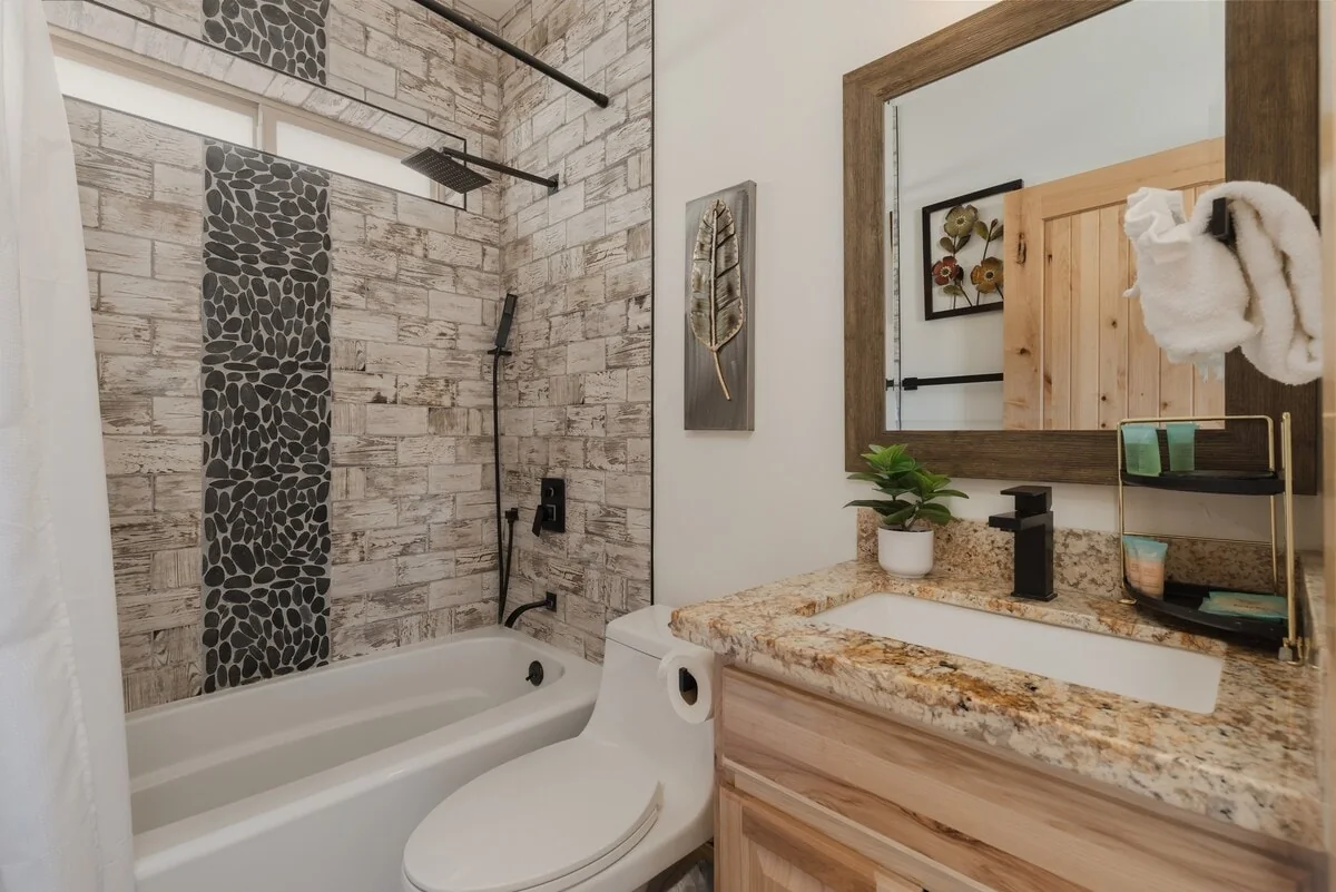 Guest bathroom with tub shower and granite vanity